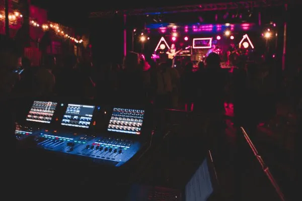 R&eacute;gie son professionnelle en concert avec pupitre de mixage et sc&egrave;ne &eacute;clair&eacute;e.